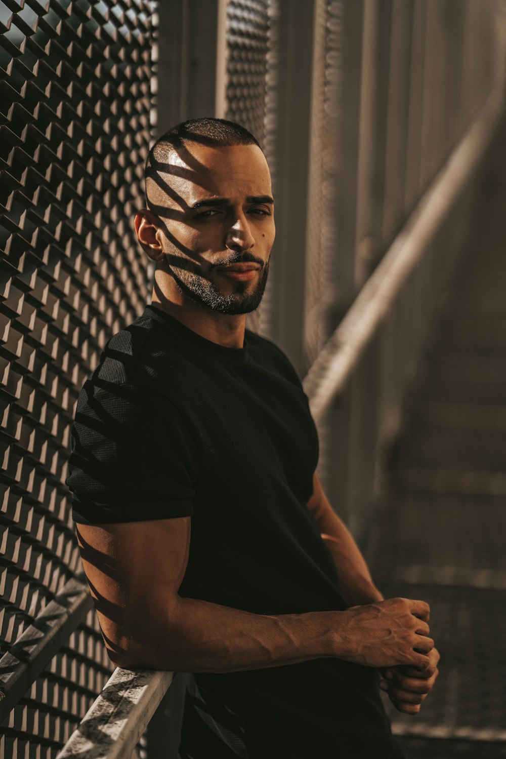 a man with tape on his face leaning against a fence