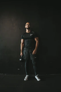a man in a black shirt and black shorts