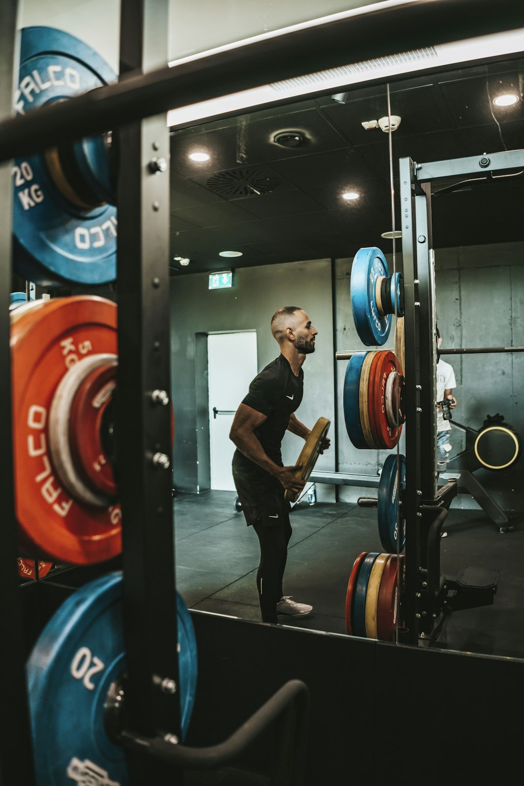 A lifter setting up under a loaded barbell in a gym
