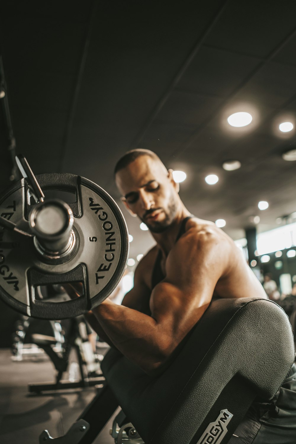 a man squatting on a bench in a gym