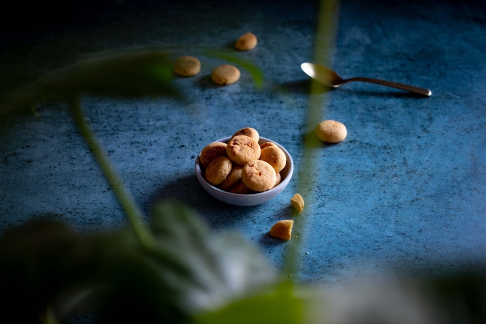 a bowl filled with cookies sitting on top of a blue table