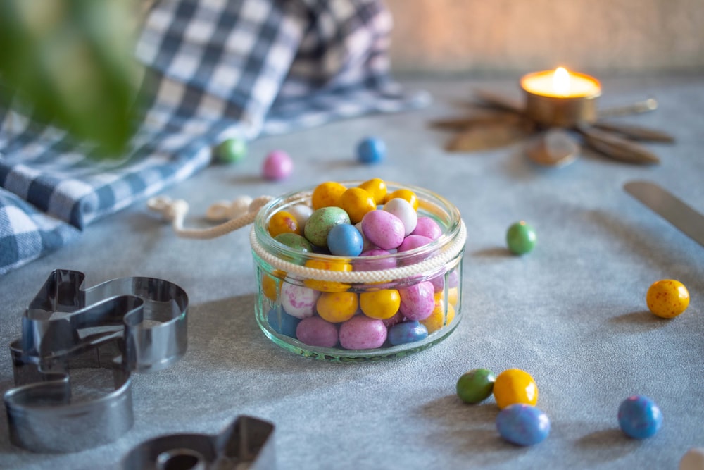 a glass jar filled with candy sitting on top of a table