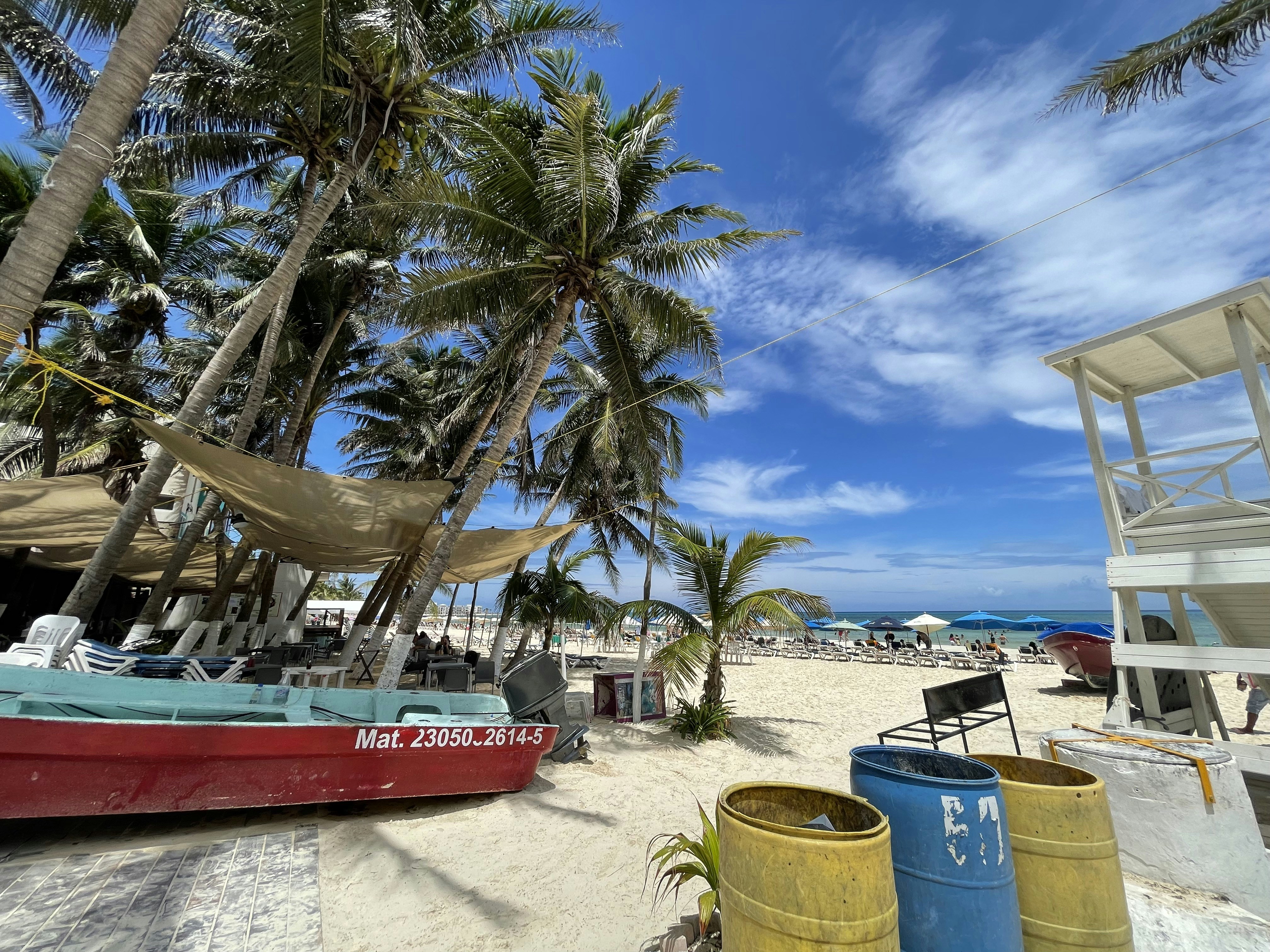 a red boat sitting on top of a sandy beach