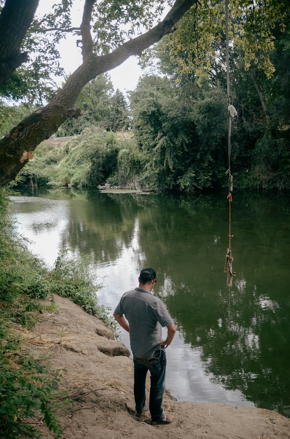 a man standing next to a body of water