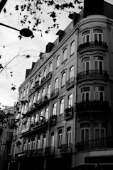a black and white photo of a building with resident apartments with balconies