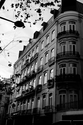a black and white photo of a building with resident apartments with balconies