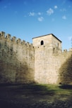 a stone castle wall with a clock tower