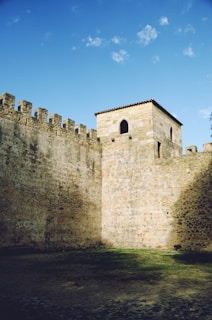 a stone castle wall with a clock tower