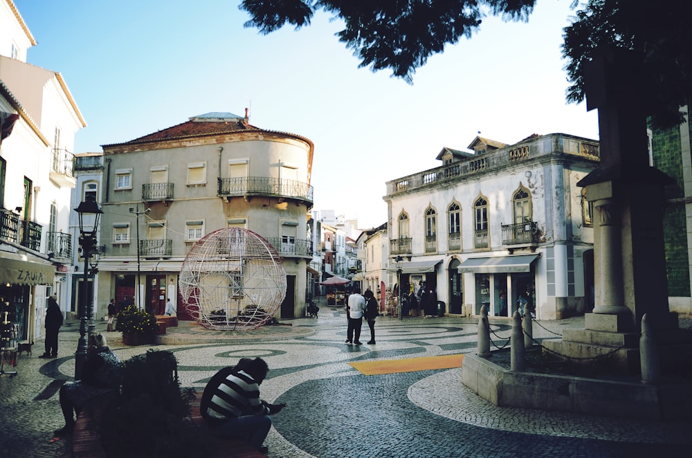 a couple of people sitting on a bench in front of a building