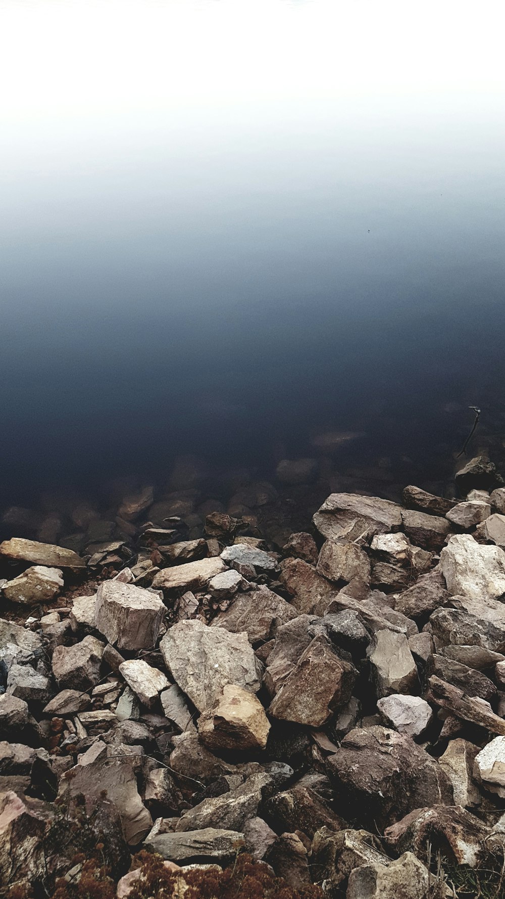 a pile of rocks sitting on top of a body of water