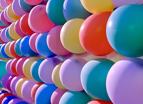 a bunch of balloons are lined up against a wall
