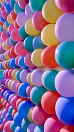 a bunch of balloons are lined up against a wall