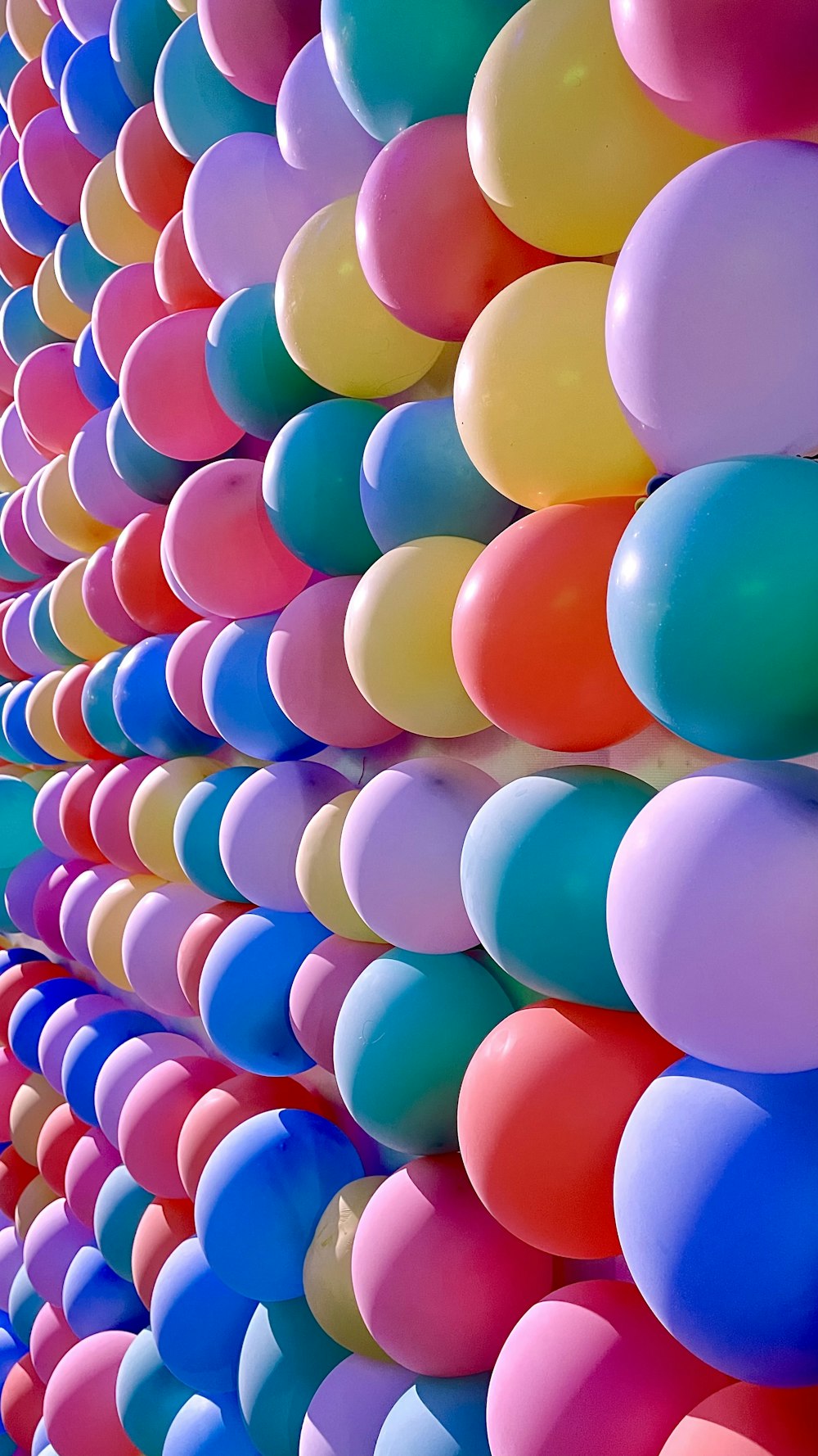 a bunch of balloons are lined up against a wall