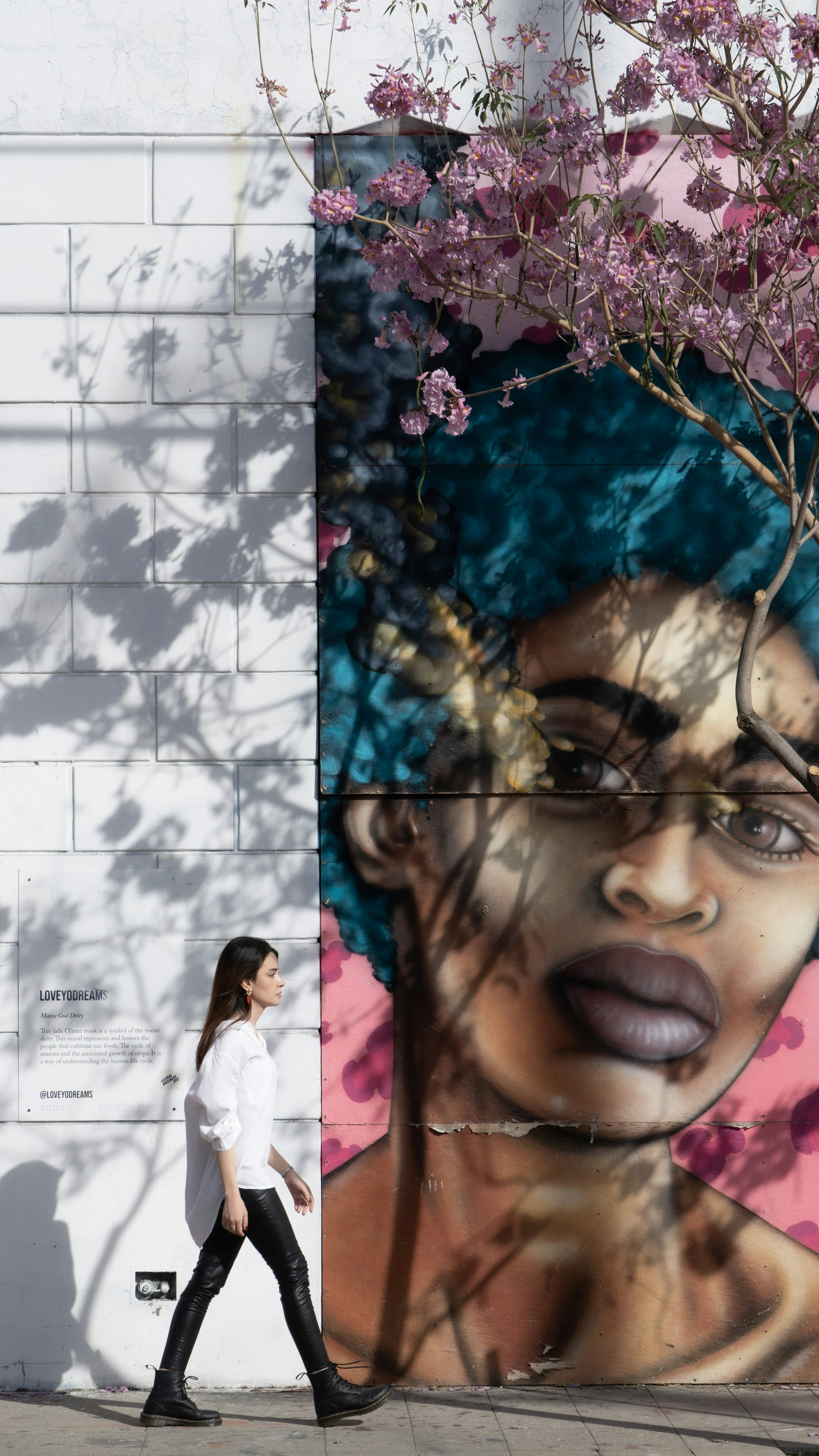 Eine Frau geht an einer Wand mit einem Gemälde vorbei