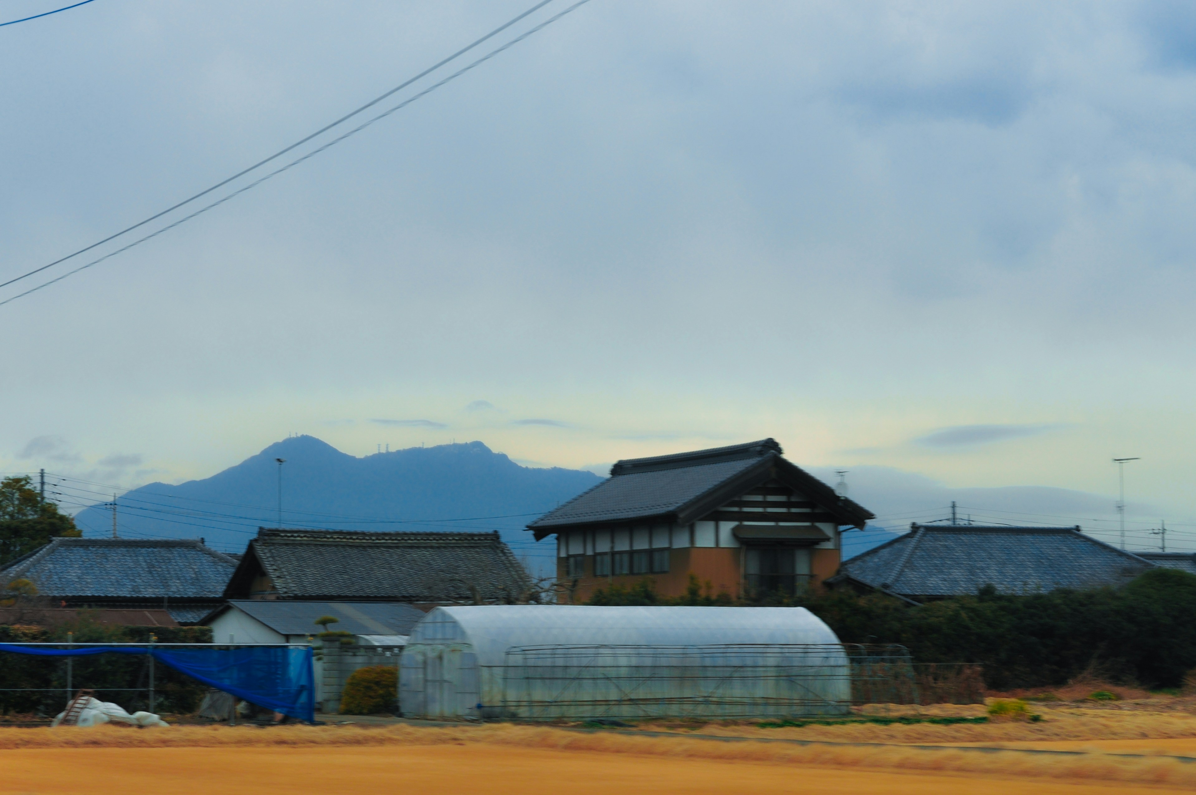 a rural area with houses and mountains in the background