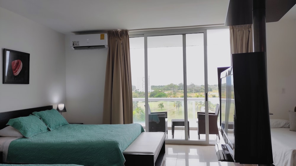 a bed room with a neatly made bed and a flat screen tv