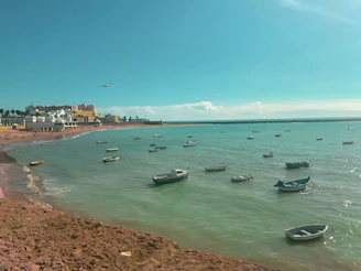 Sunset over the calm turquoise waters of Bayahibe beach with small boats anchored nearby.