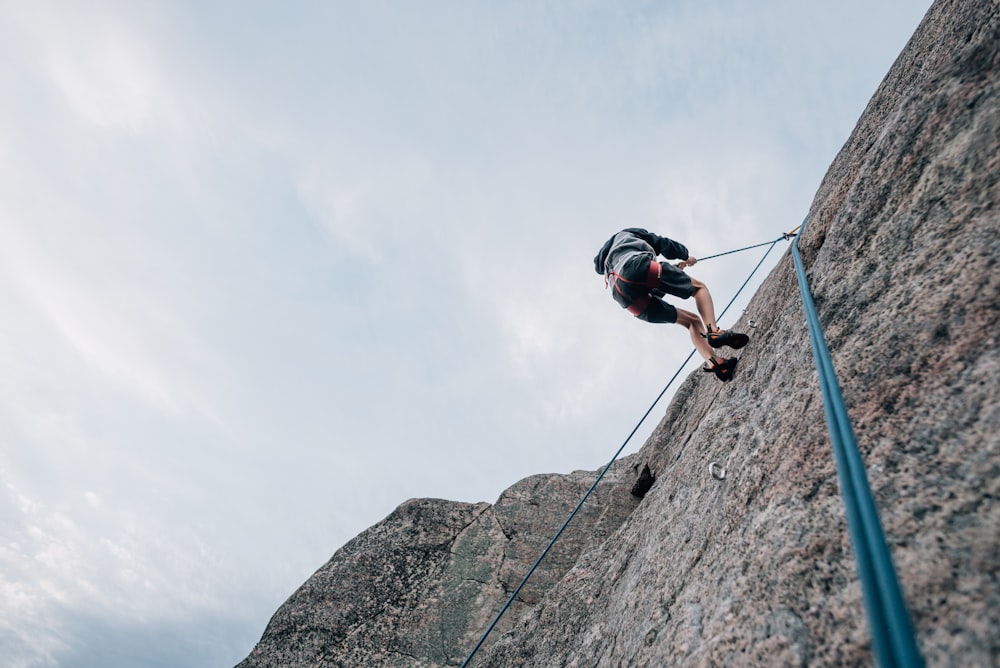 a man climbing up the side of a mountain