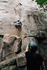 a man on a rock climbing up the side of a mountain