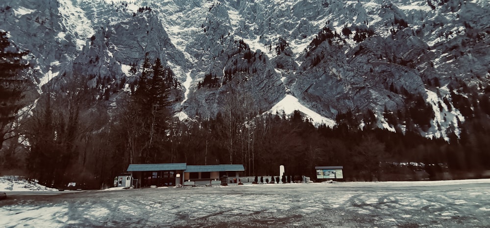 a snow covered mountain with a small cabin in the foreground