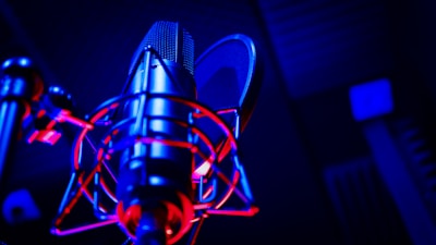 Close-up of a microphone in a recording studio with soft lighting.