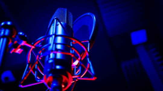 Close-up of a microphone with warm stage lighting, capturing an intimate recording moment.