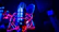 Close-up of a young musician smiling in a neon-lit recording studio.