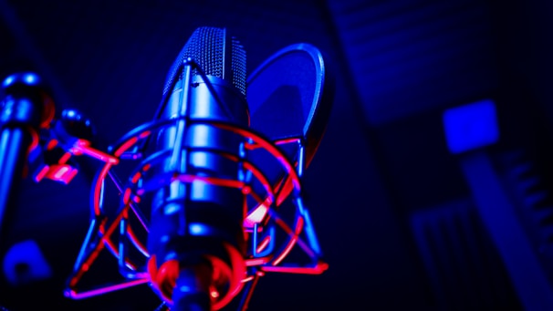 Close-up of a professional microphone with colorful LED lights in the background