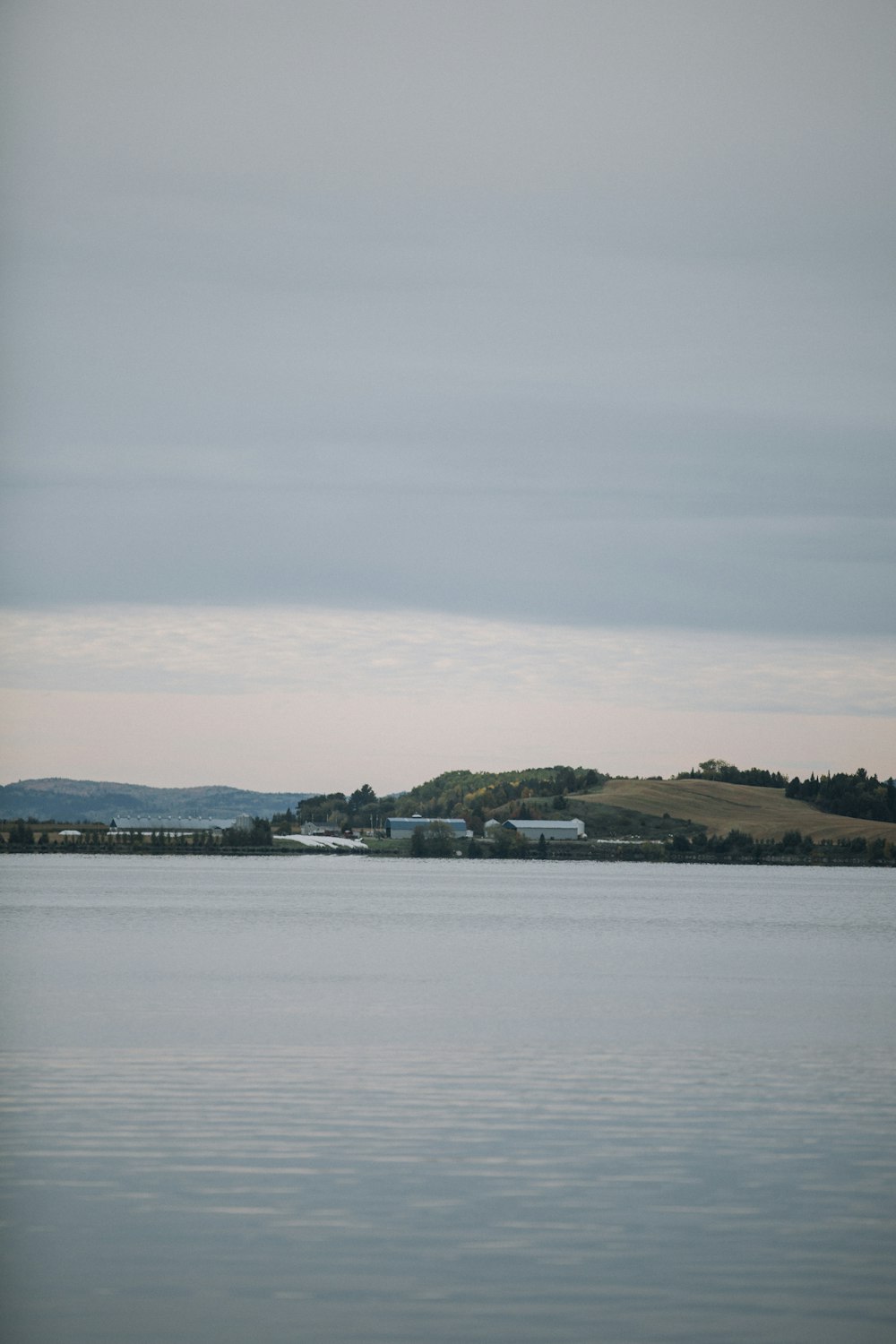 a large body of water with a hill in the background