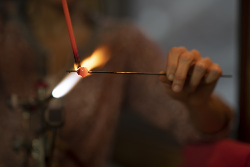 a person holding a lit candle in their hand