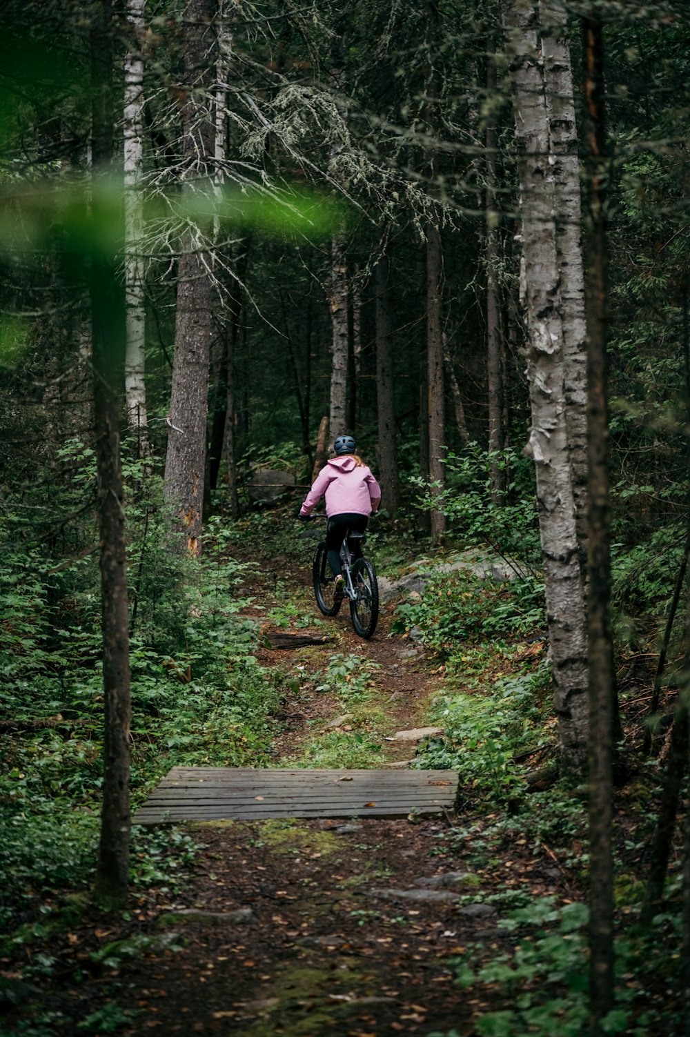 a person riding a bike through a forest