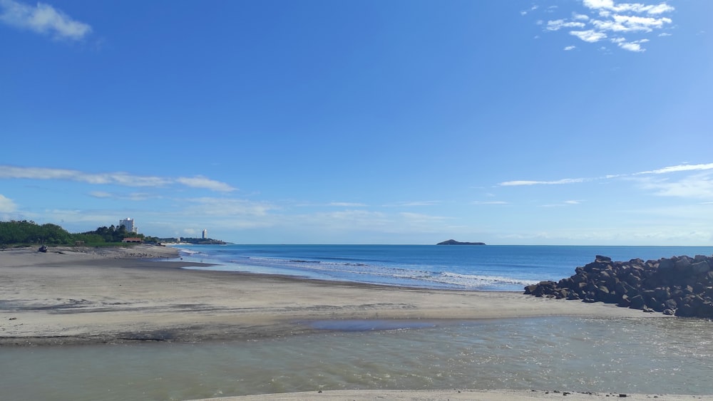 a sandy beach with a small island in the distance