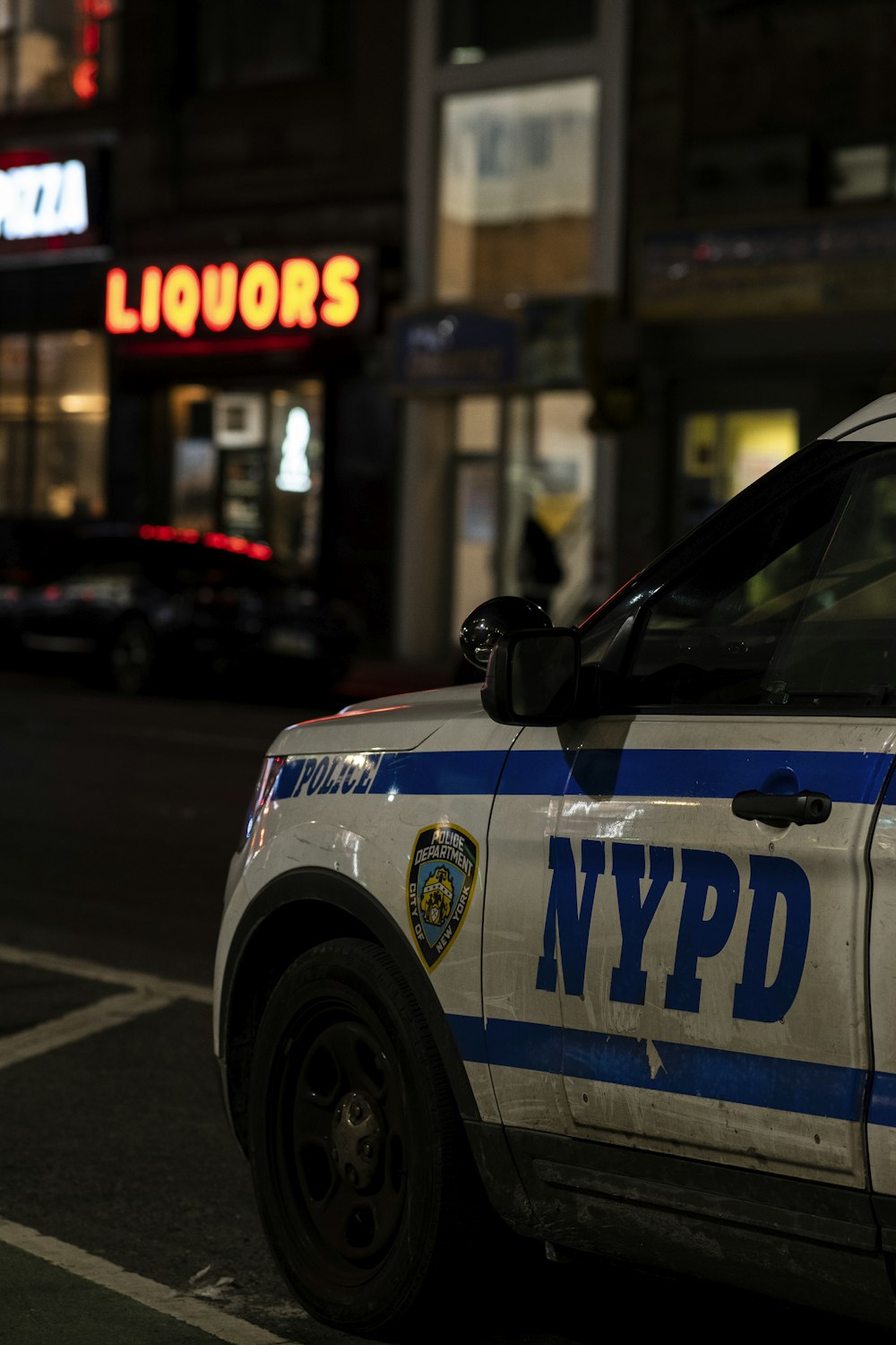 a nypd police car parked on the side of the street
