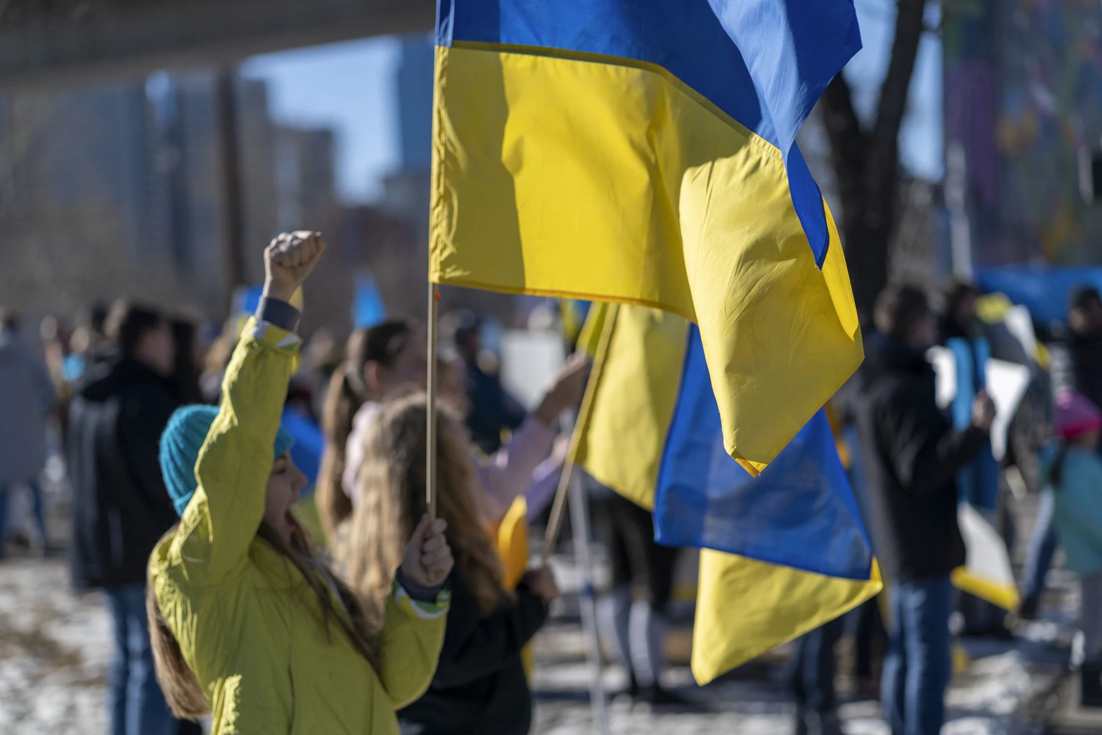 A woman holding a Ukrainian flag in a crowd