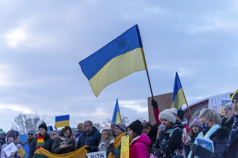 a crowd of people holding flags and signs