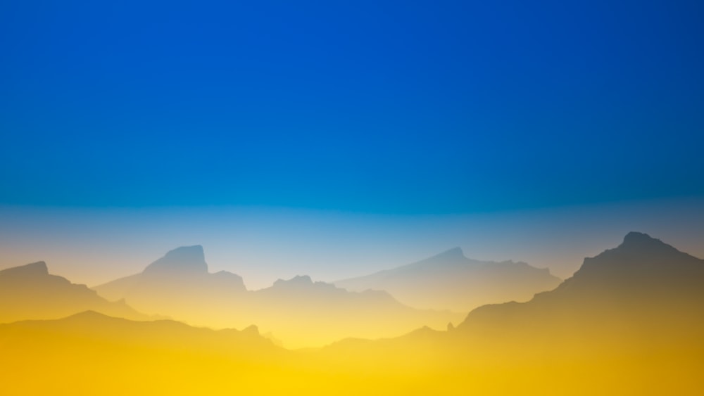 a view of a mountain range with a blue sky in the background