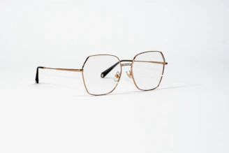 a pair of glasses sitting on top of a white surface