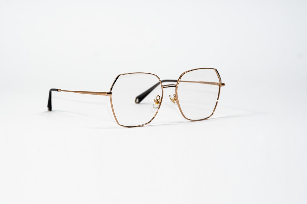 a pair of glasses sitting on top of a white surface