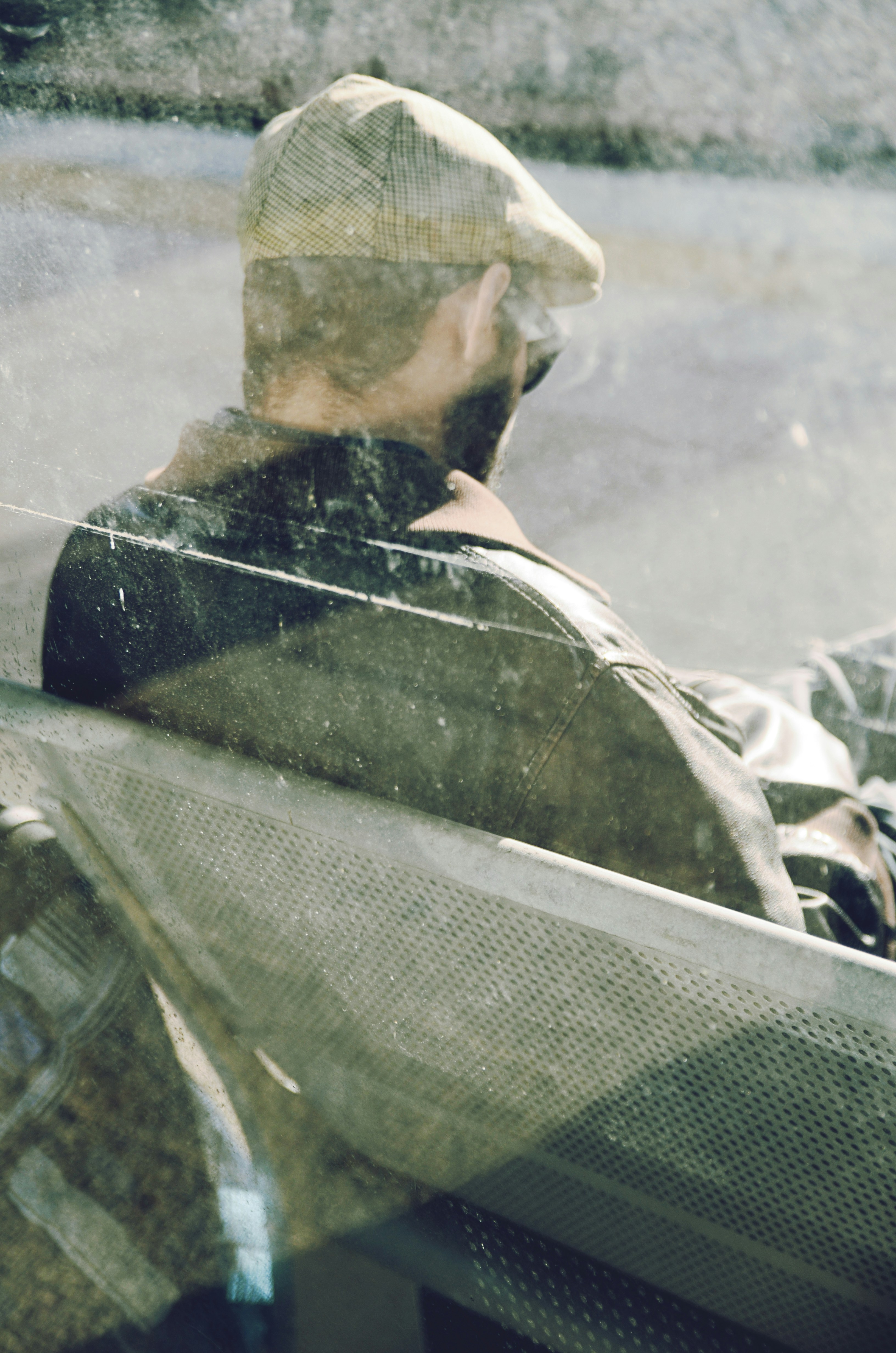 a man sitting on a bus looking out the window