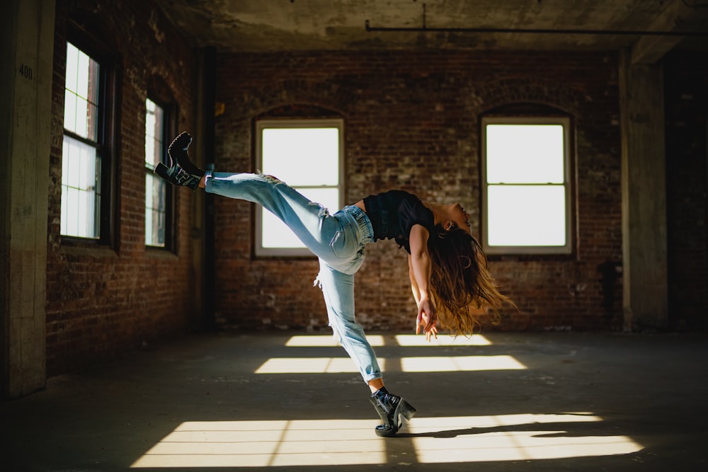 a woman doing a handstand in an empty room