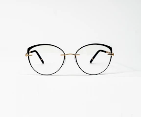 a pair of glasses sitting on top of a white surface
