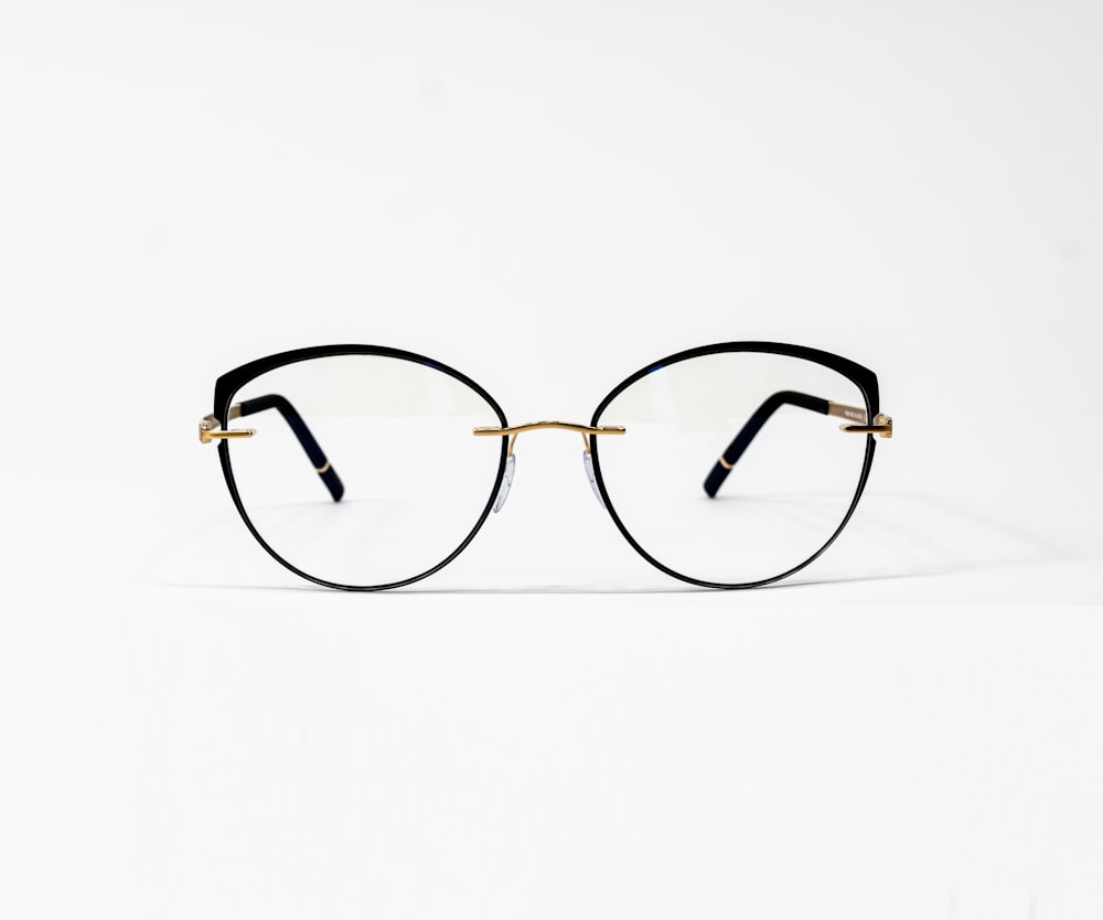 a pair of glasses sitting on top of a white surface