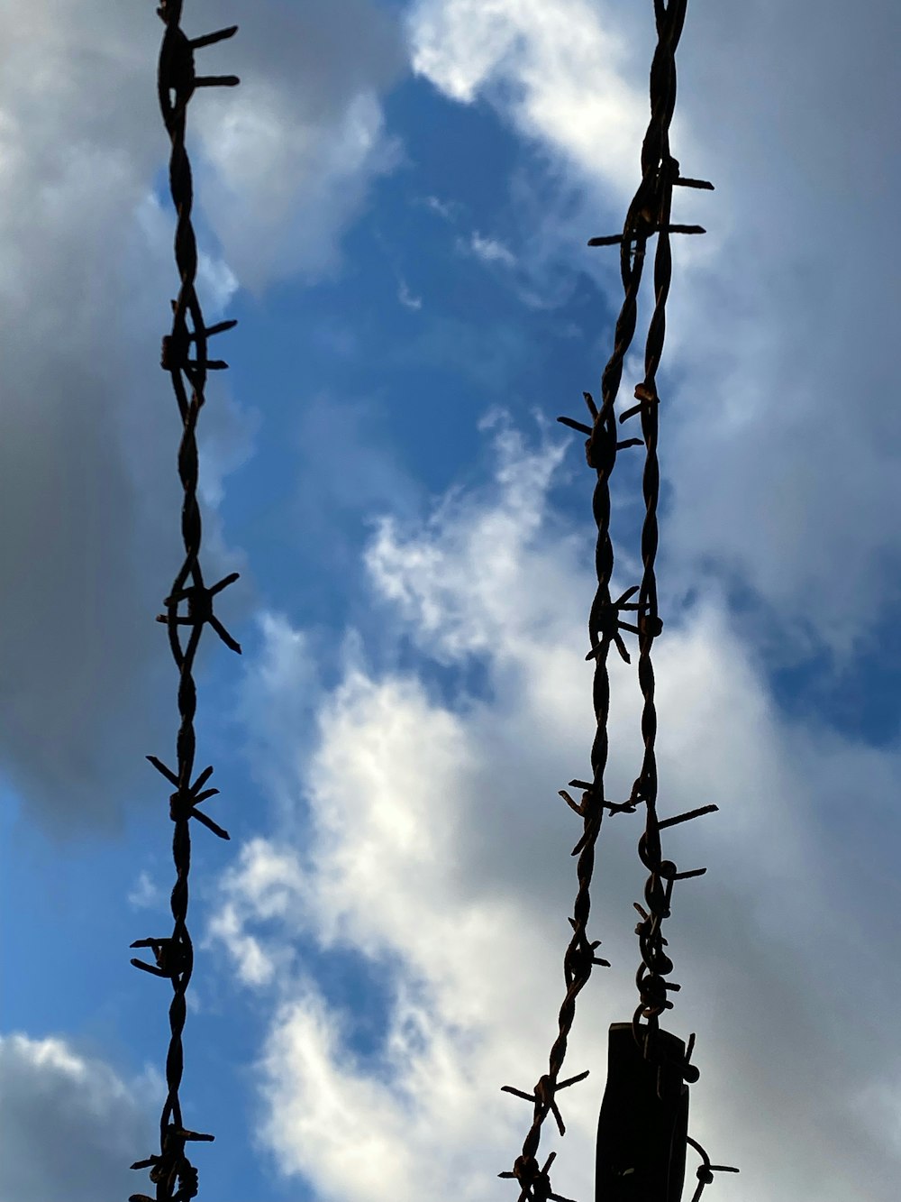 a chain link fence with a cloudy sky in the background