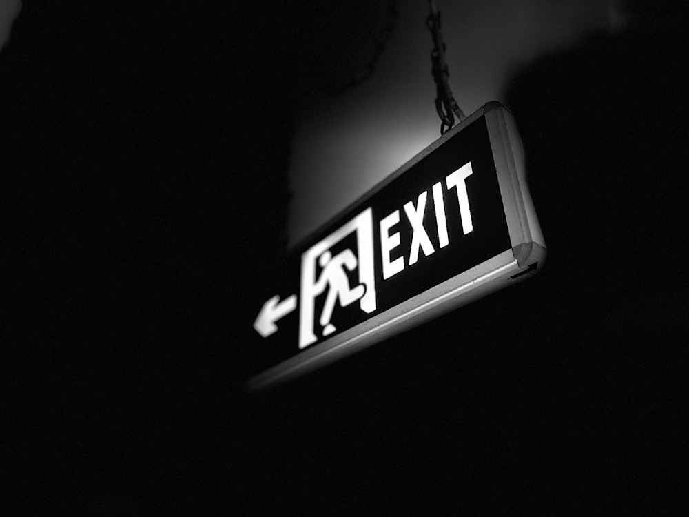 a black and white photo of a exit sign