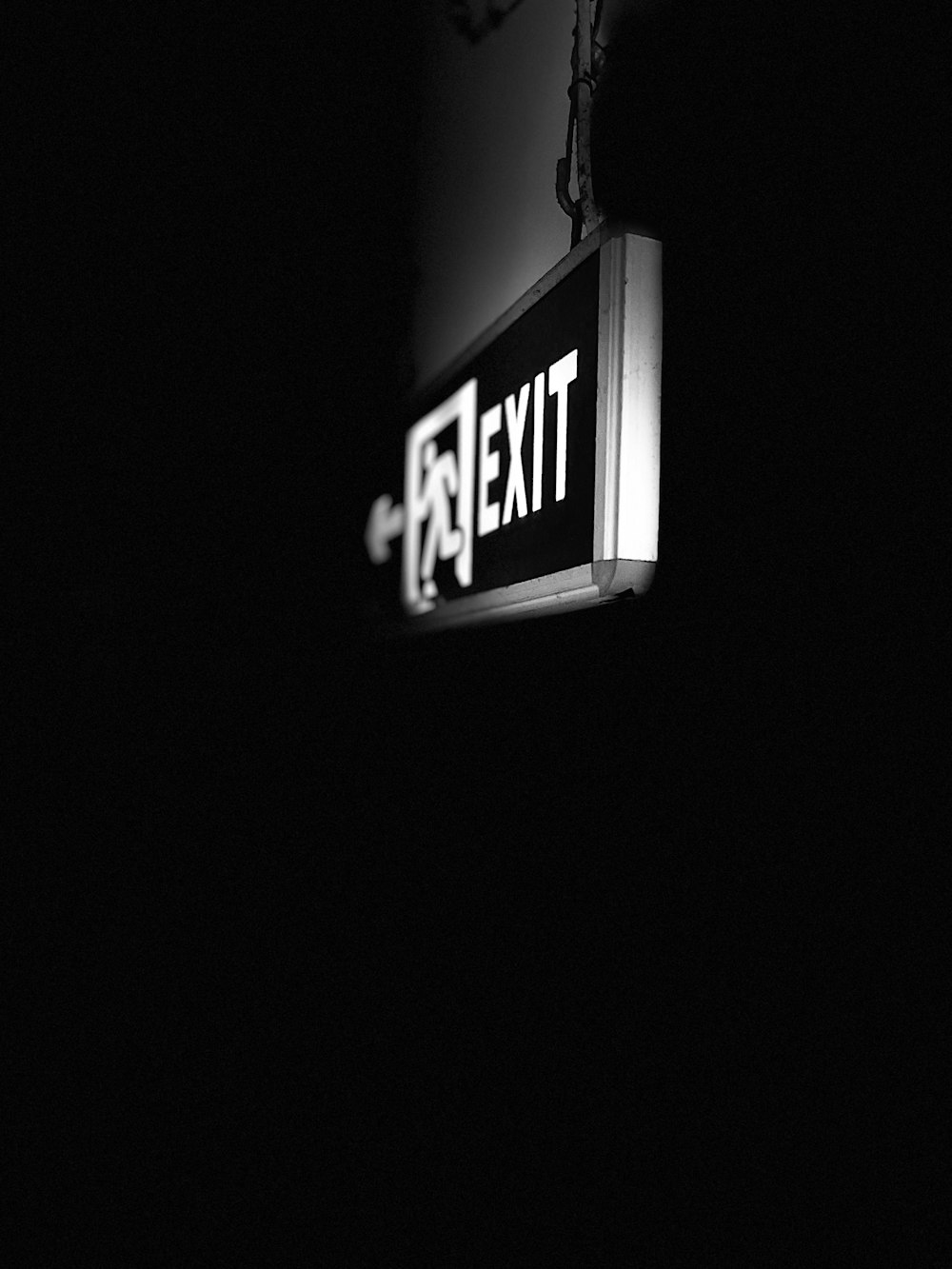 a black and white photo of a exit sign