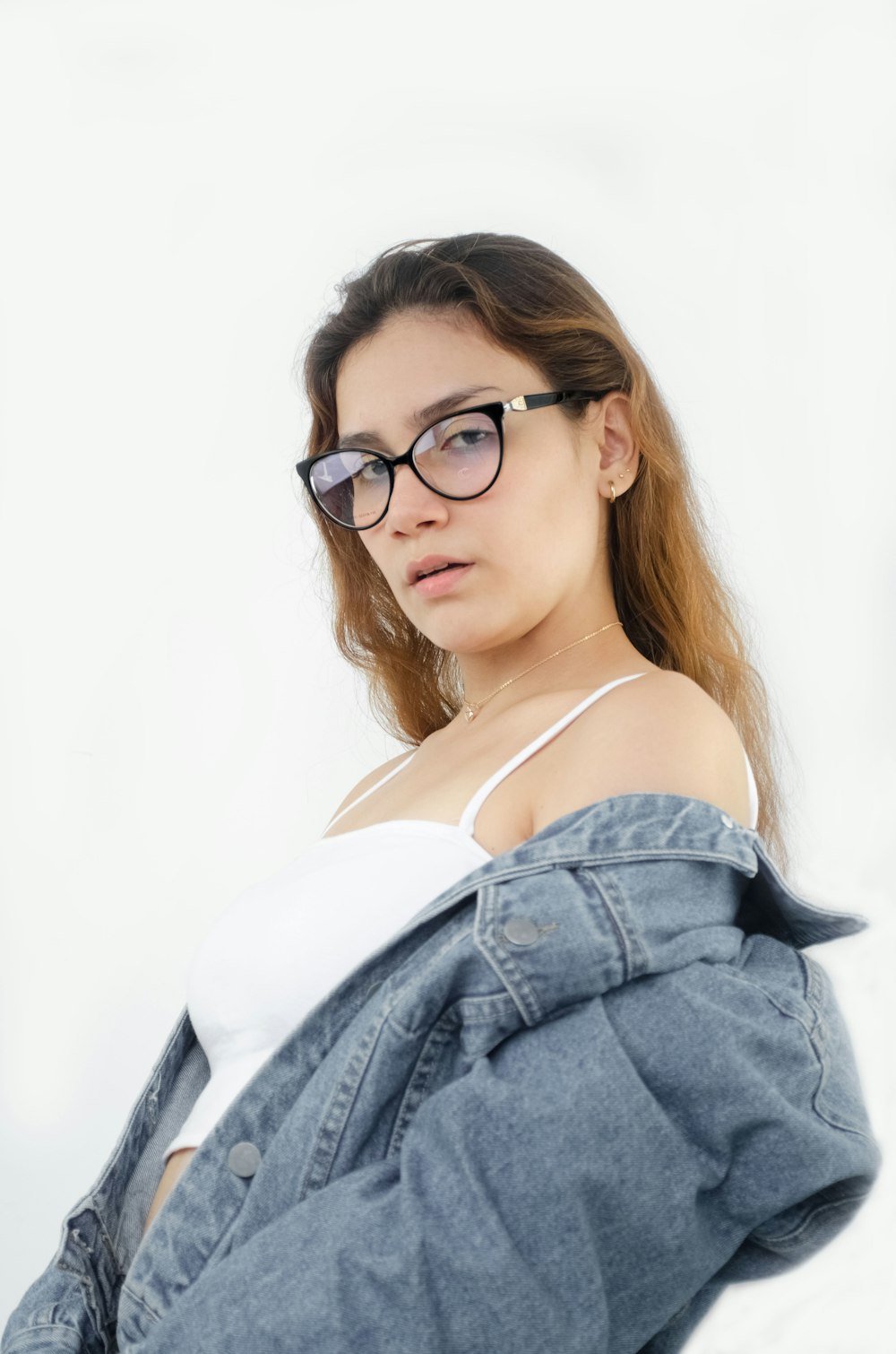 a woman wearing glasses and a denim jacket