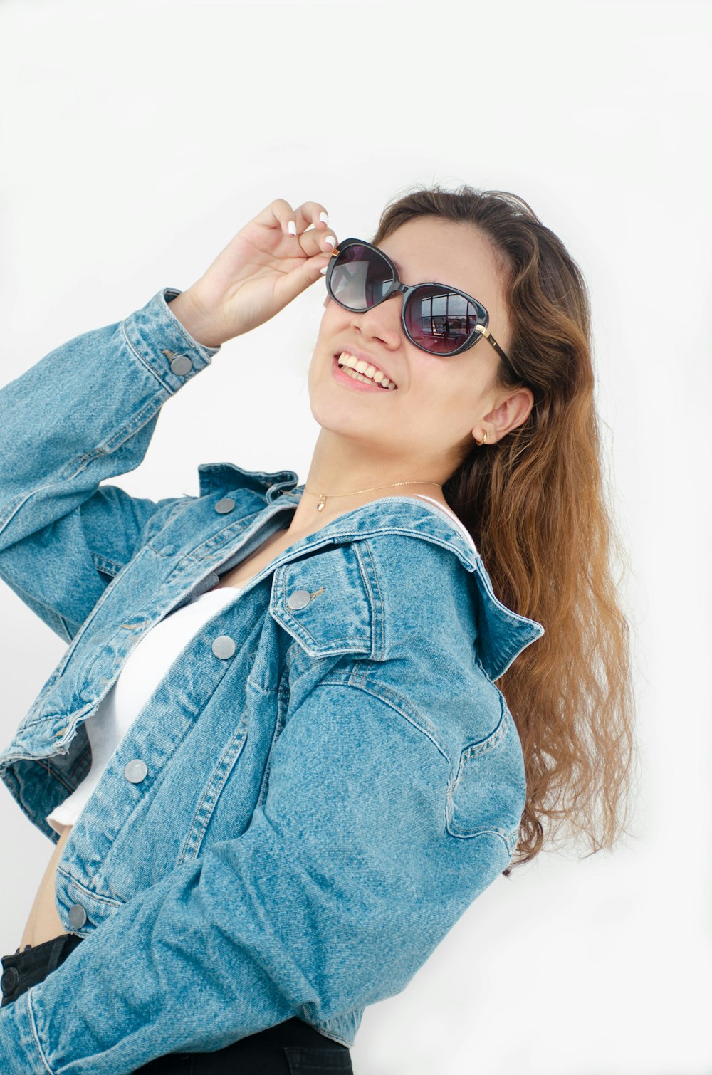 a woman wearing a jean jacket and sunglasses