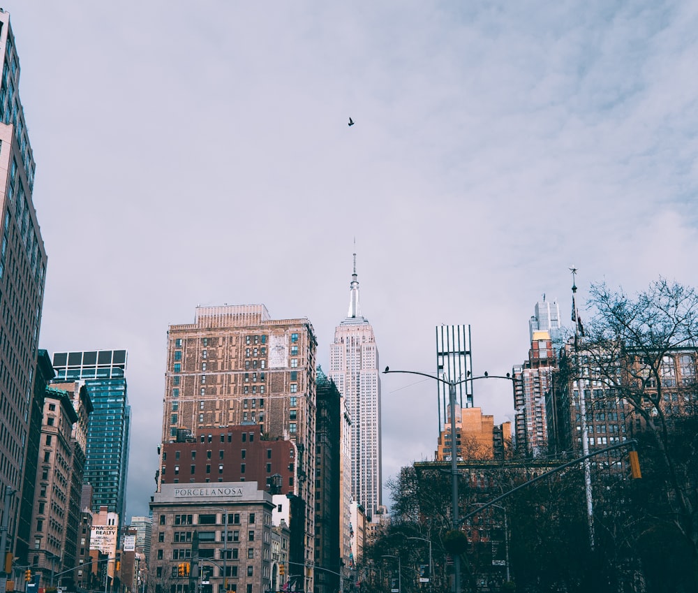 a city street filled with tall buildings under a cloudy sky