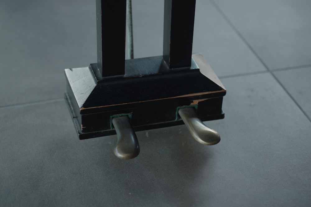 un oggetto metallico con due maniglie su un pavimento di piastrelle