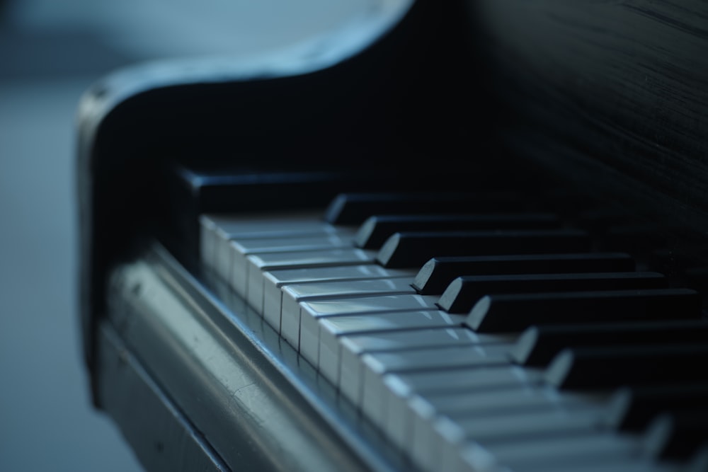 a close up of a black piano with white keys